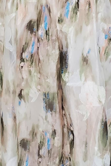 Green and blue tie dye effect dress standing against a plain background