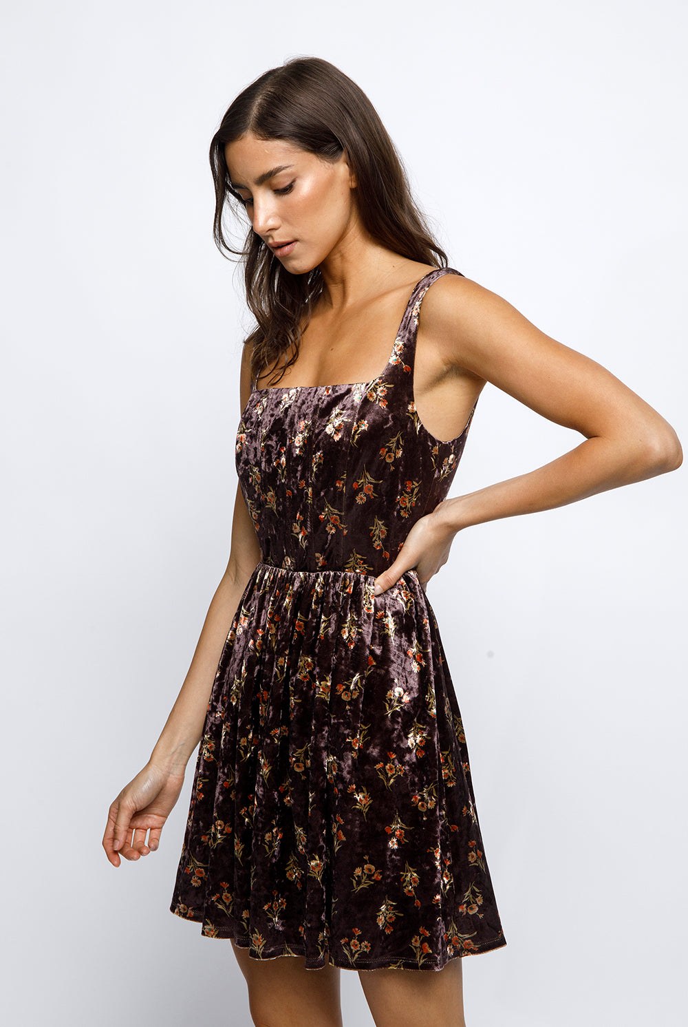 Woman wearing a brown floral mini dress against a white background