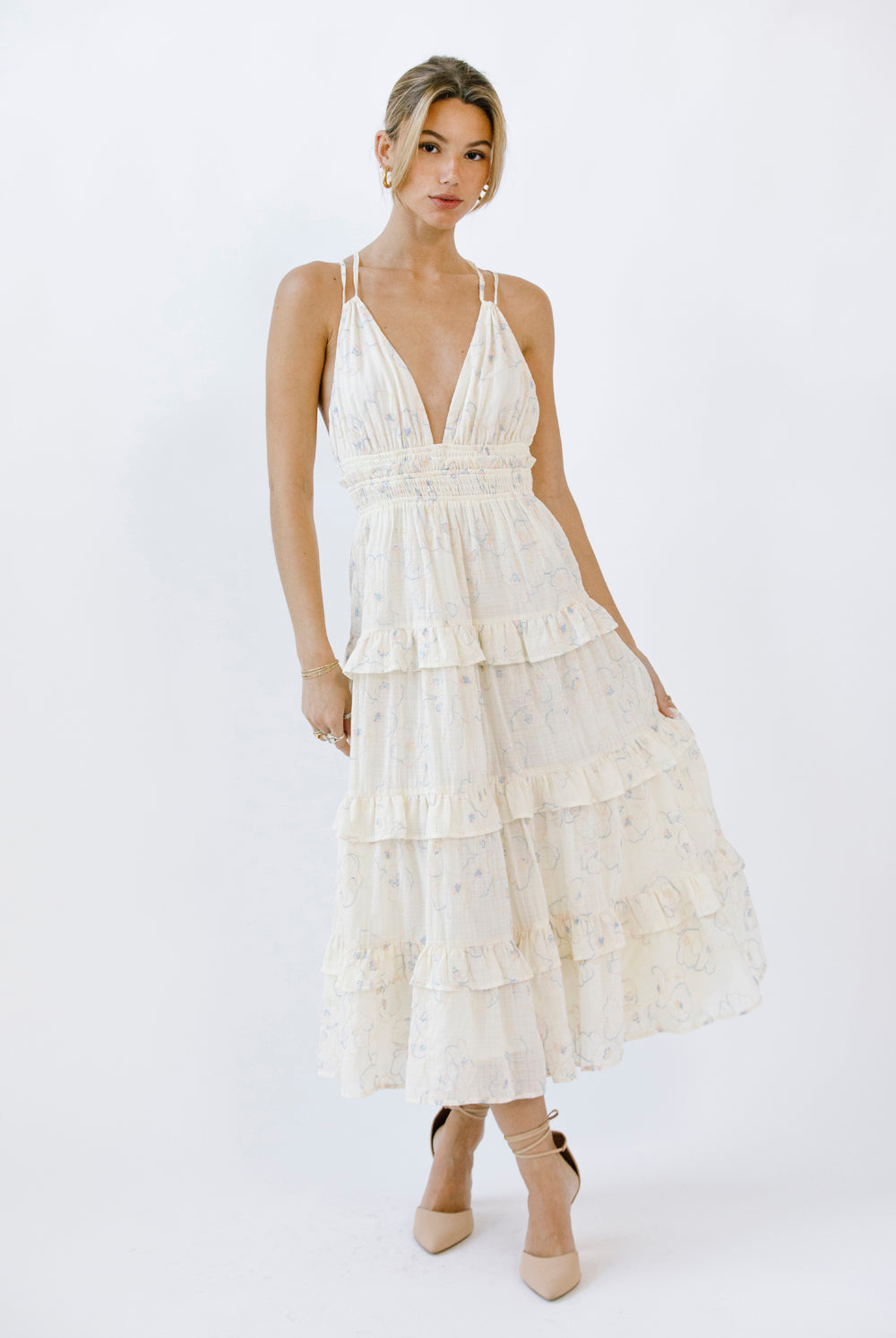 Woman wearing a cream tiered midi dress on a white background