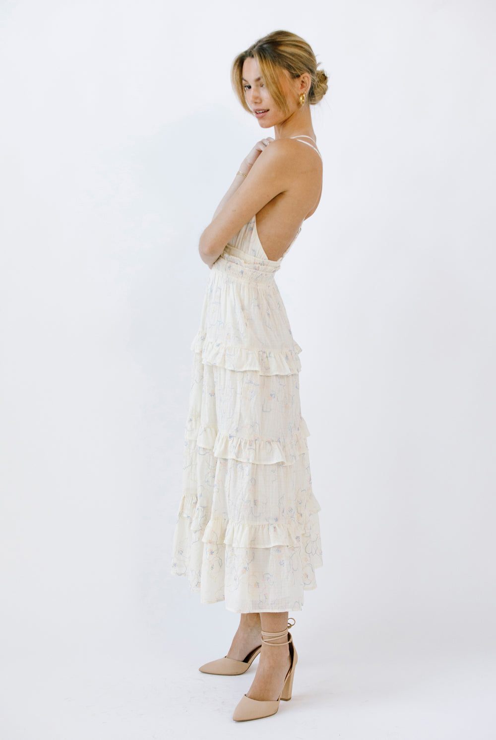Woman wearing a midi dress with ruffled layers on a white background