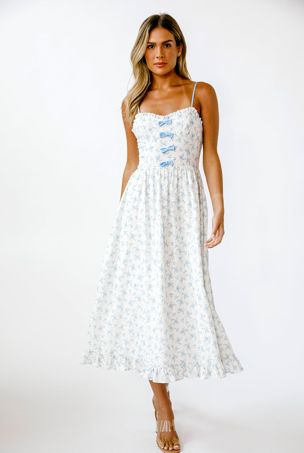 Woman wearing a white dress with blue floral patterns on a white background