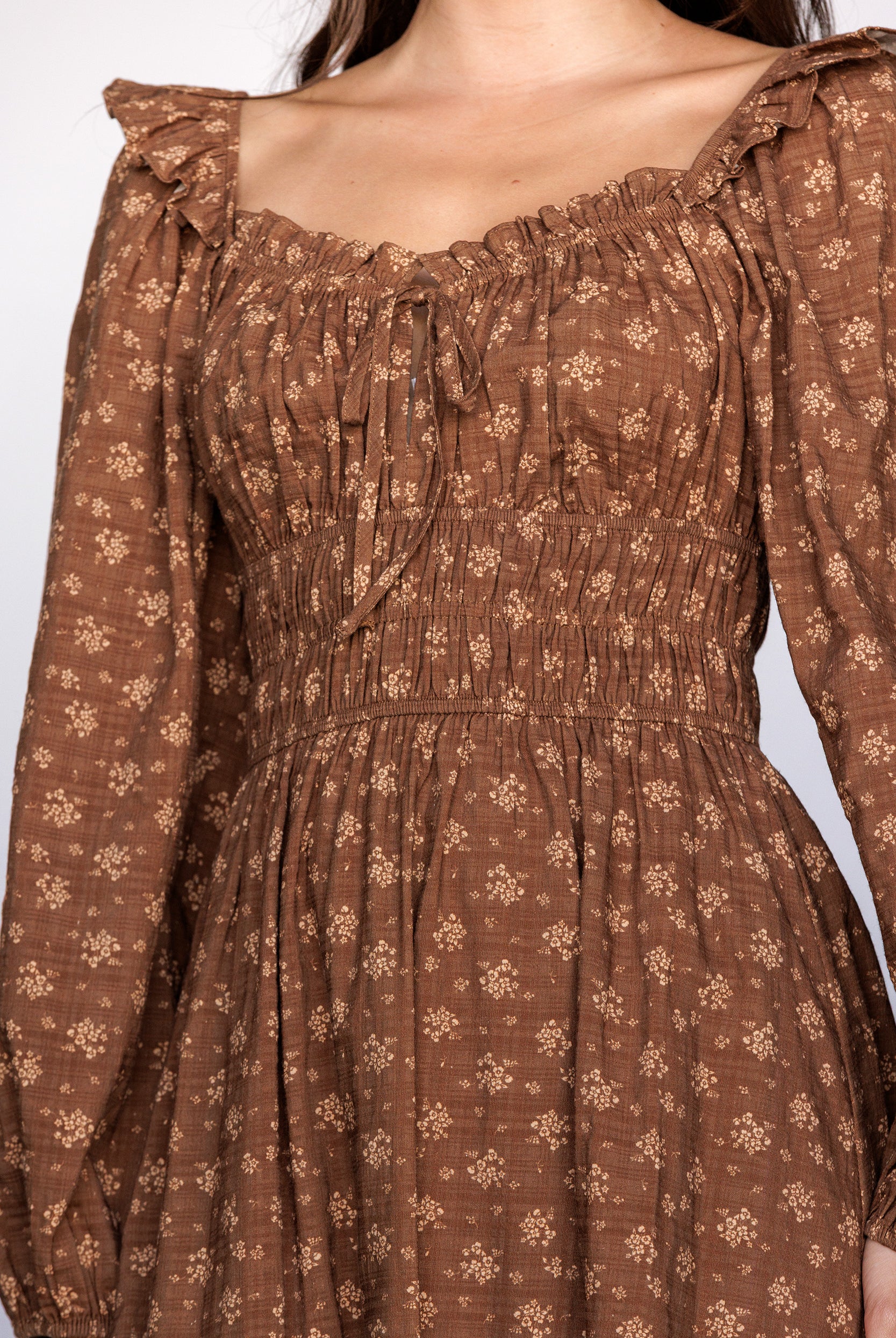 Brown floral dress with long sleeves on a white background
