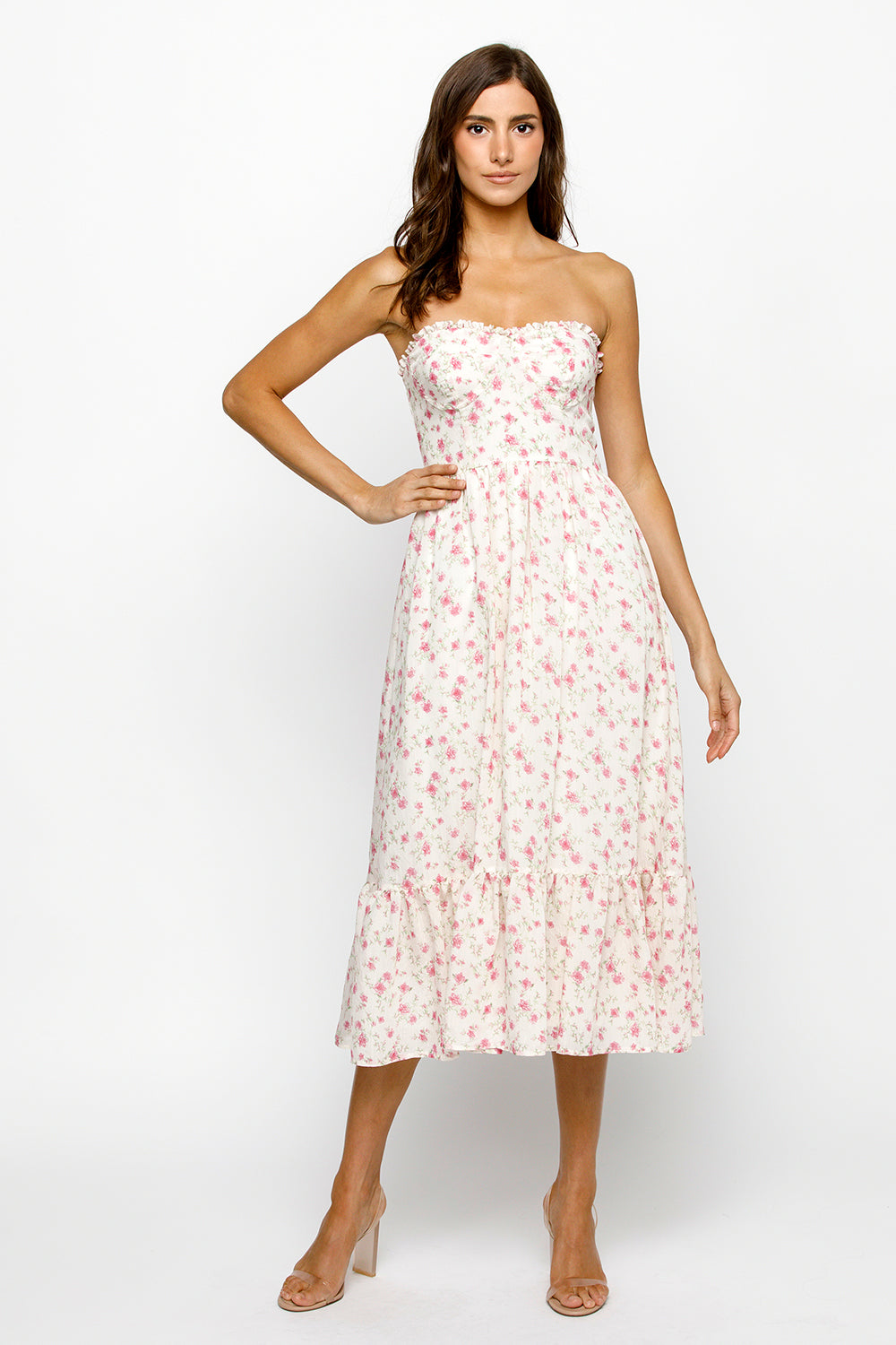 Woman wearing a strapless cream floral dress on a white background