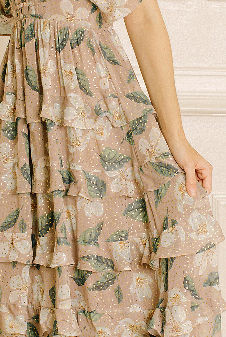 Beige dress with green leaf pattern worn by a person