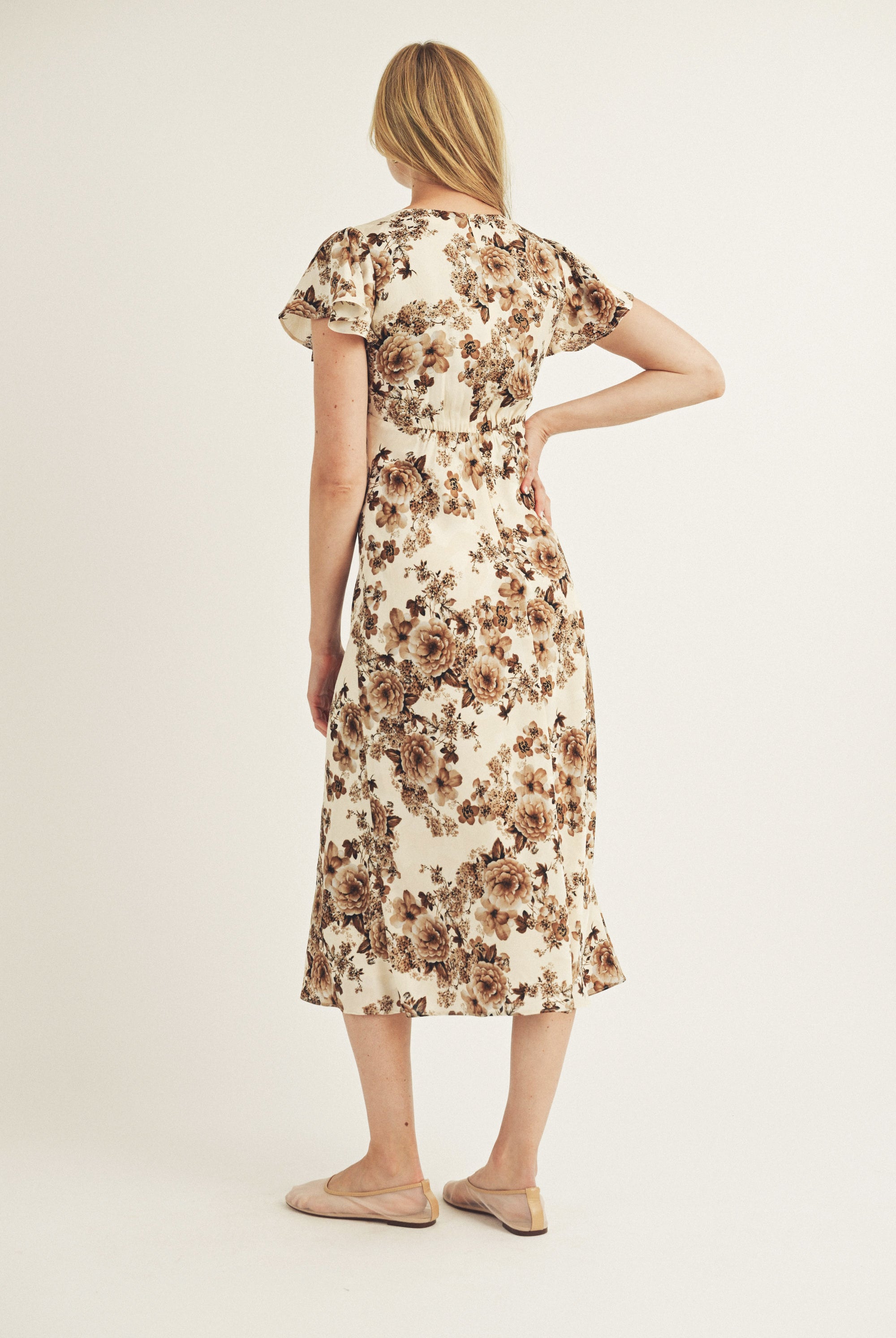 Woman wearing a floral dress on a plain background