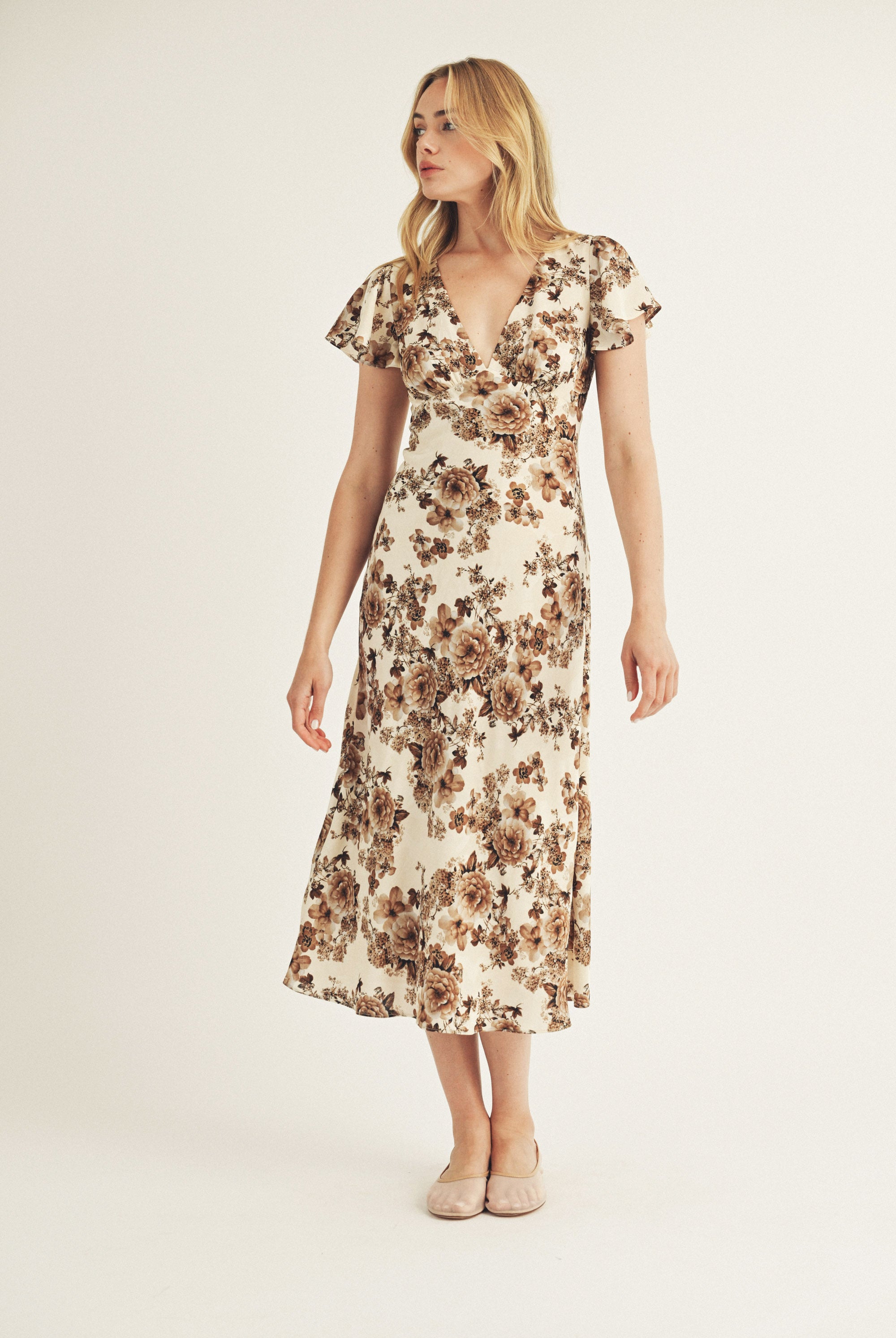 Woman wearing a floral dress on a plain background