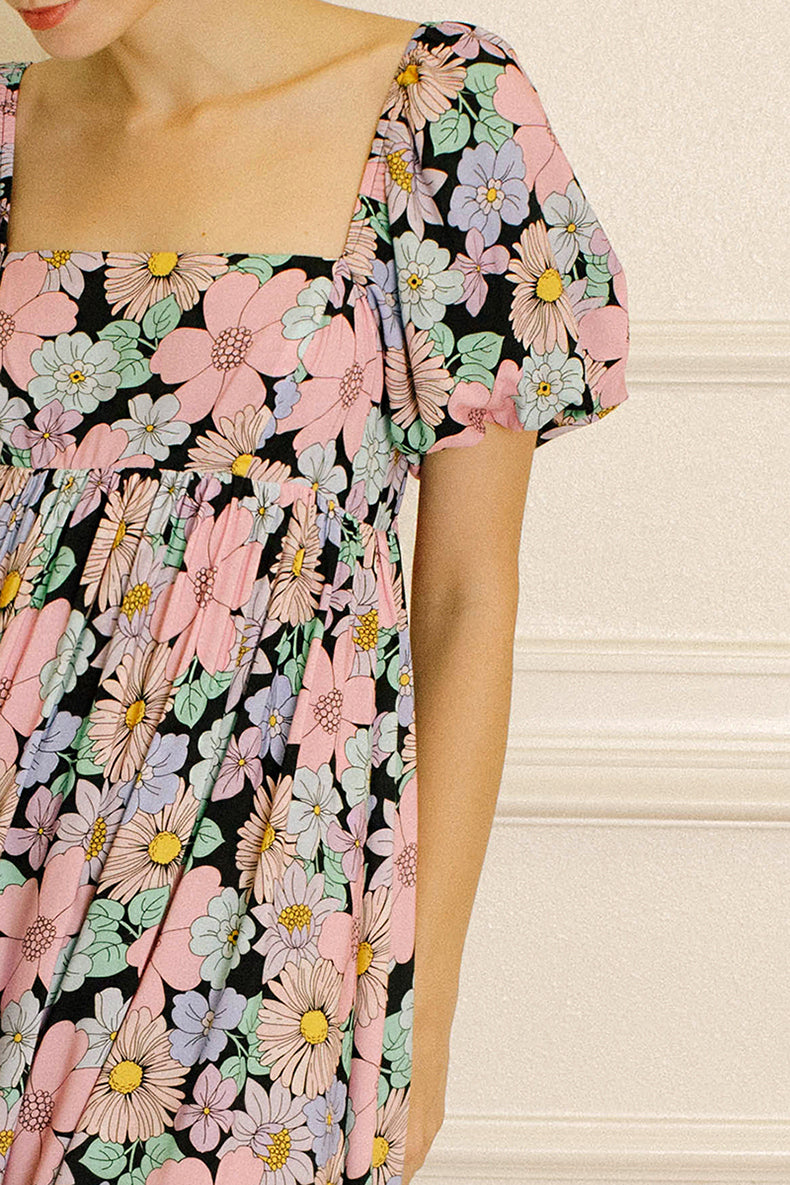 Pastel floral dress against a beige wall