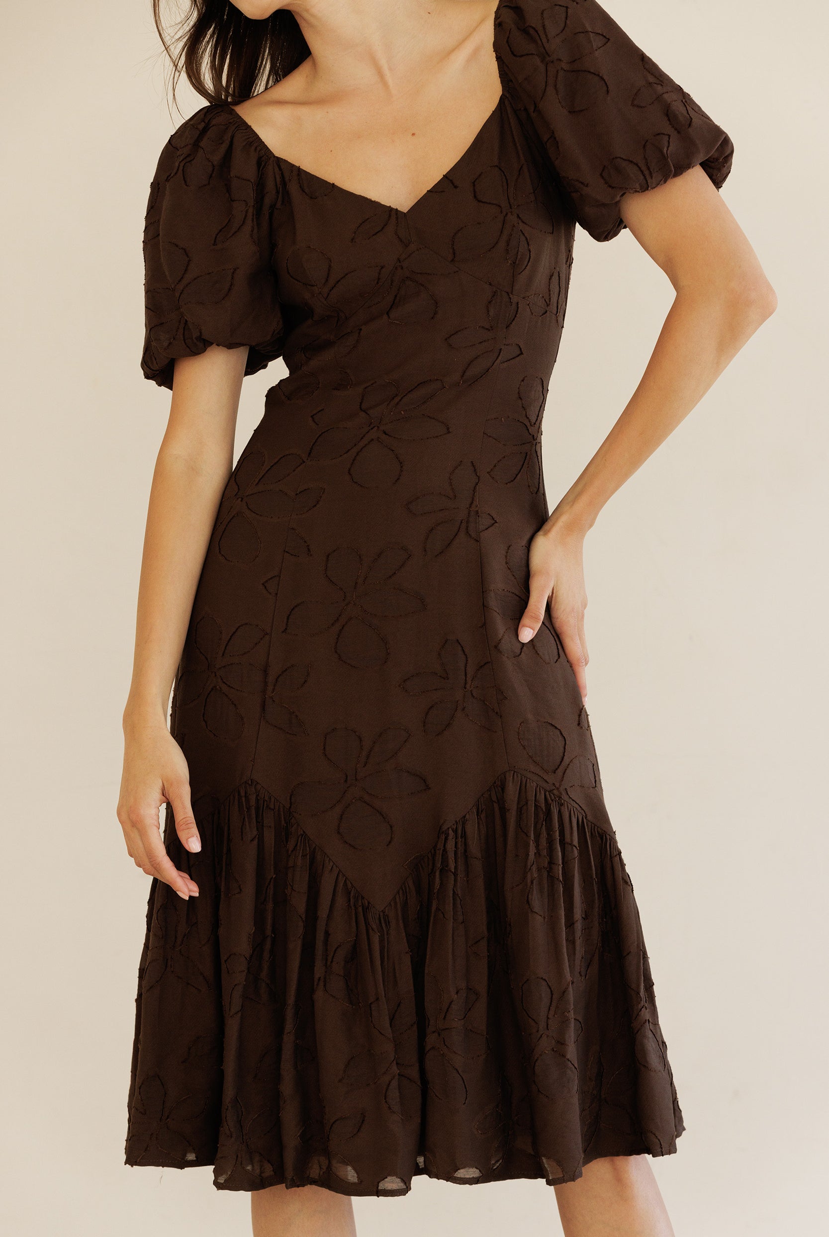 Brown dress with floral patterns on a plain background