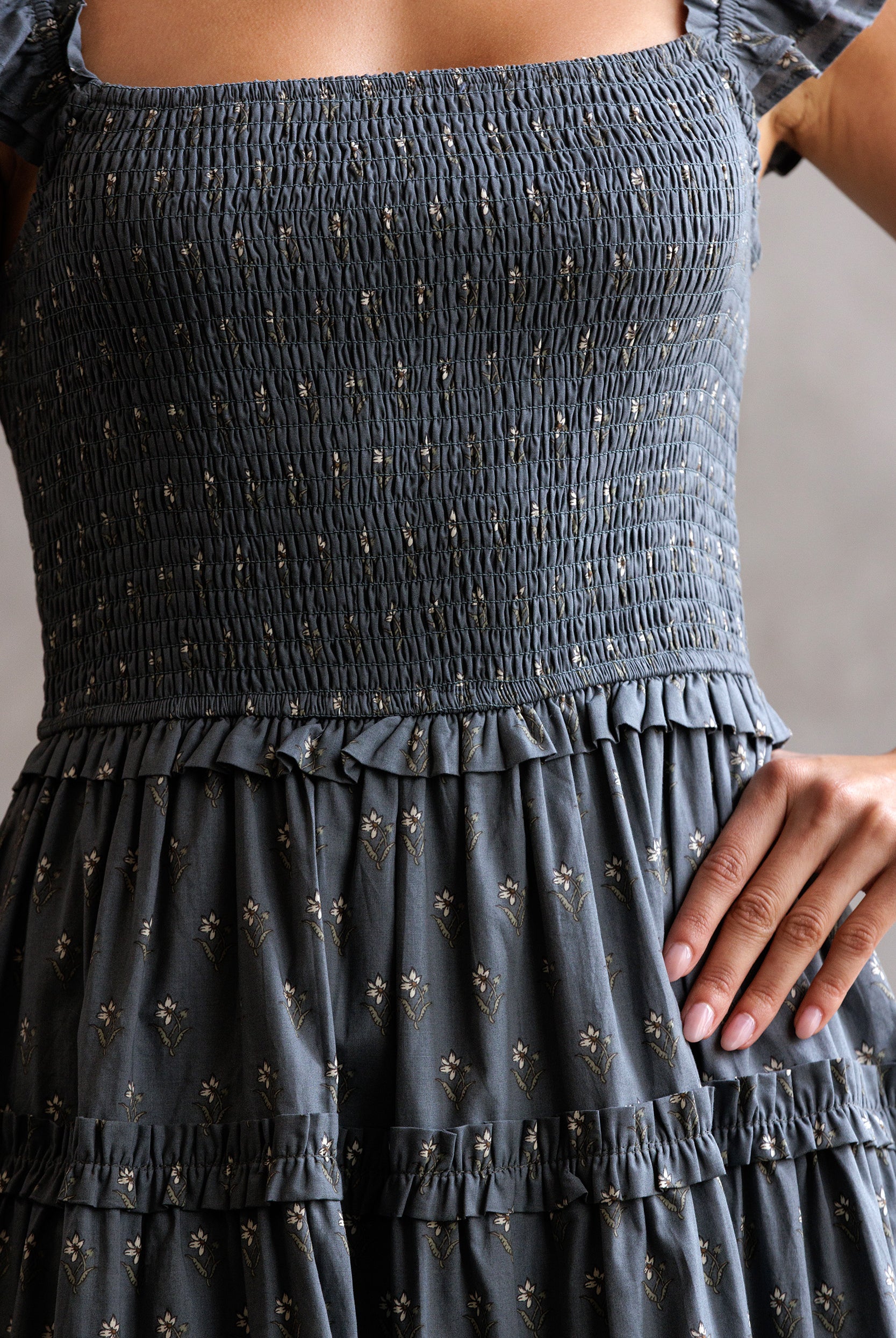 Dark gray smocked top and tiered skirt with subtle pattern on a neutral background