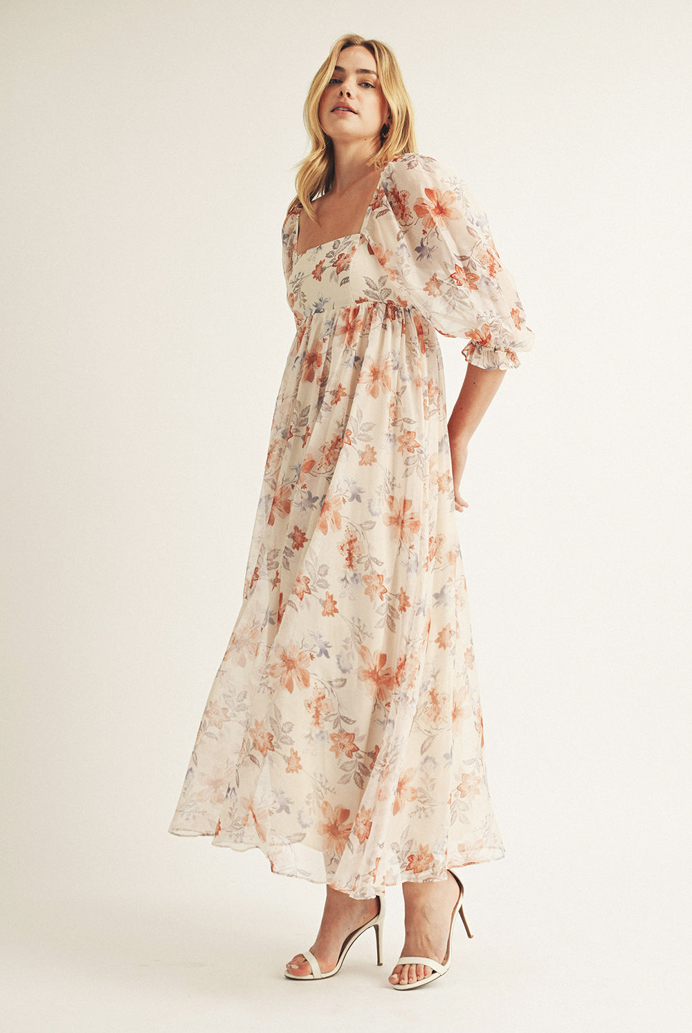 Woman wearing a beige floral dress on a white background