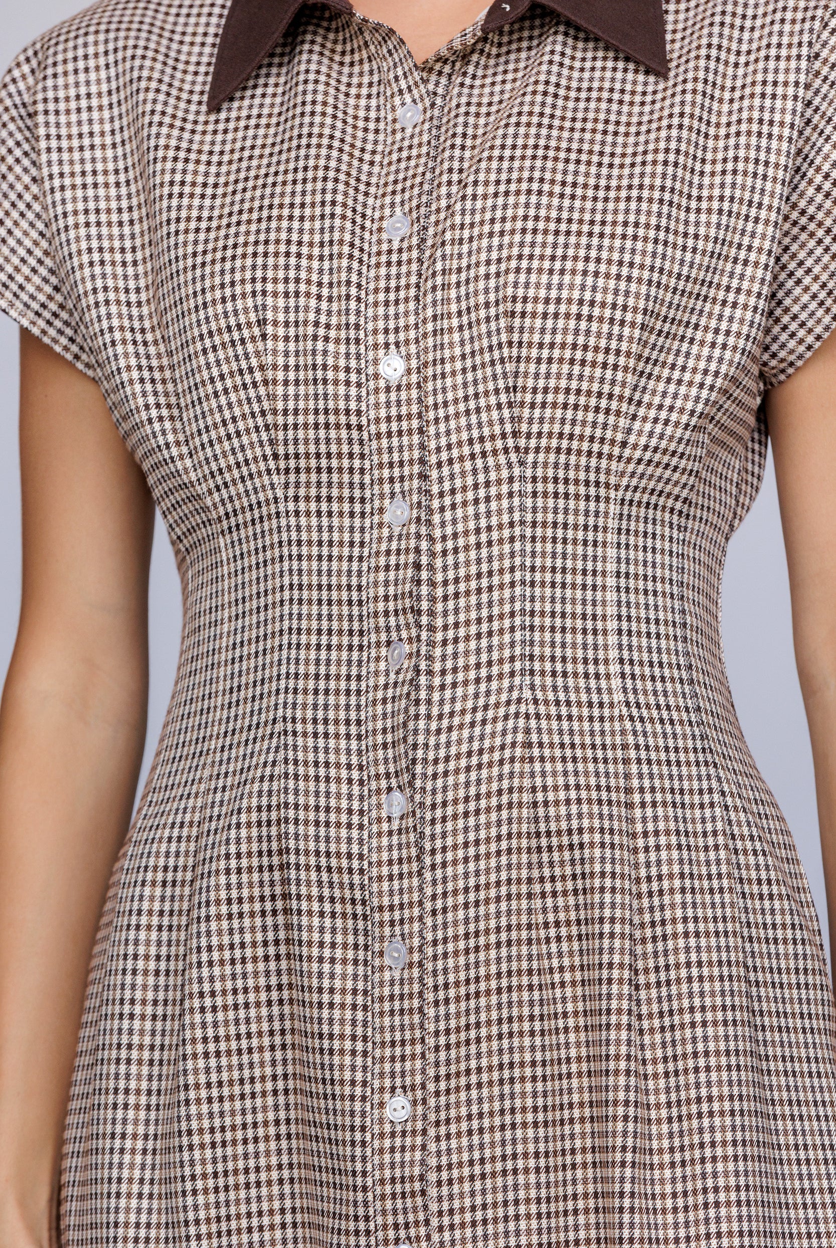 Brown and beige checkered dress with a collar on a gray background