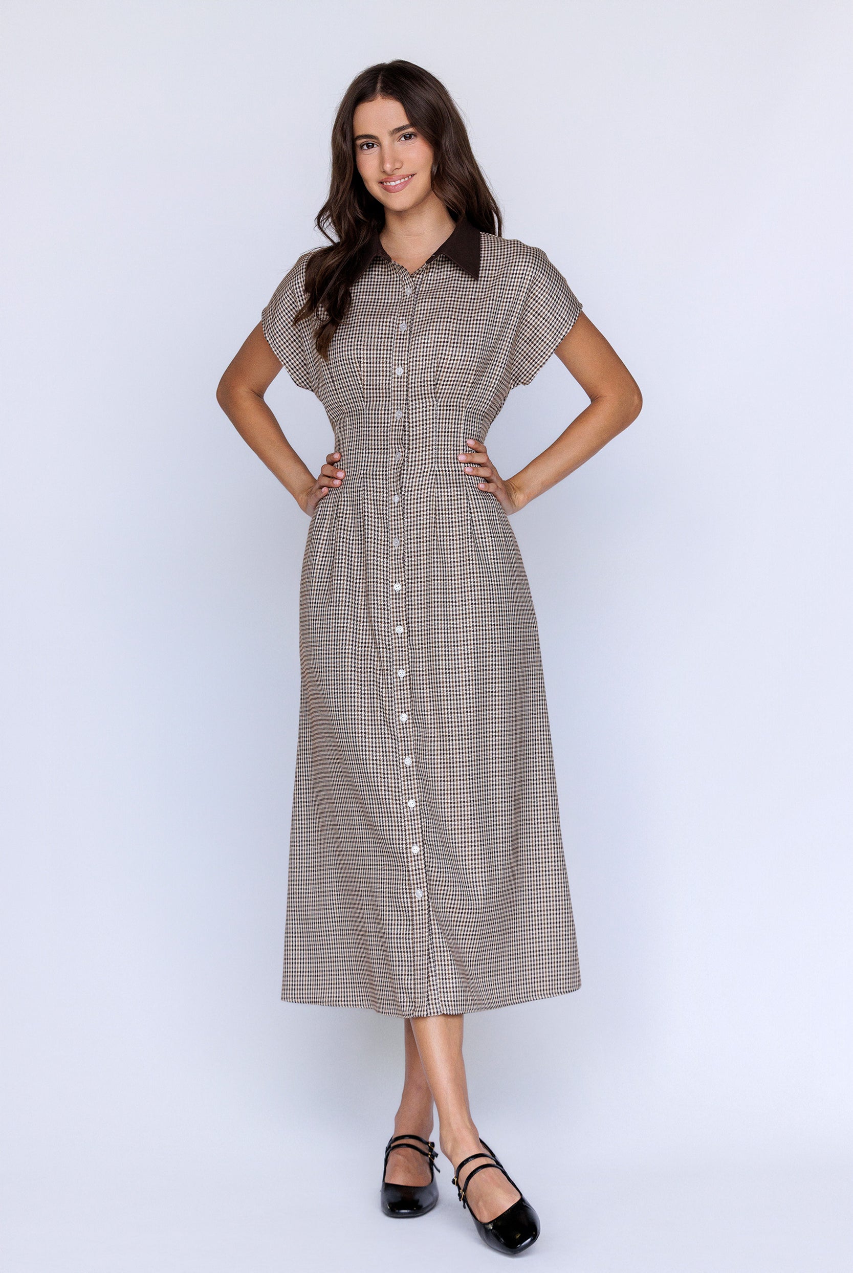 Woman wearing a brown checkered dress on a white background