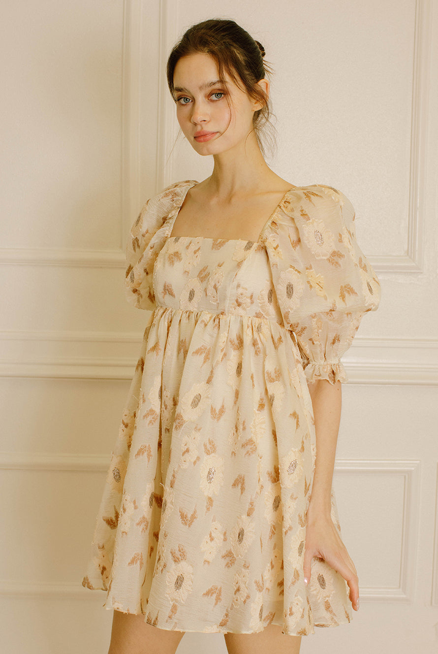 Woman wearing a beige dress with a floral pattern