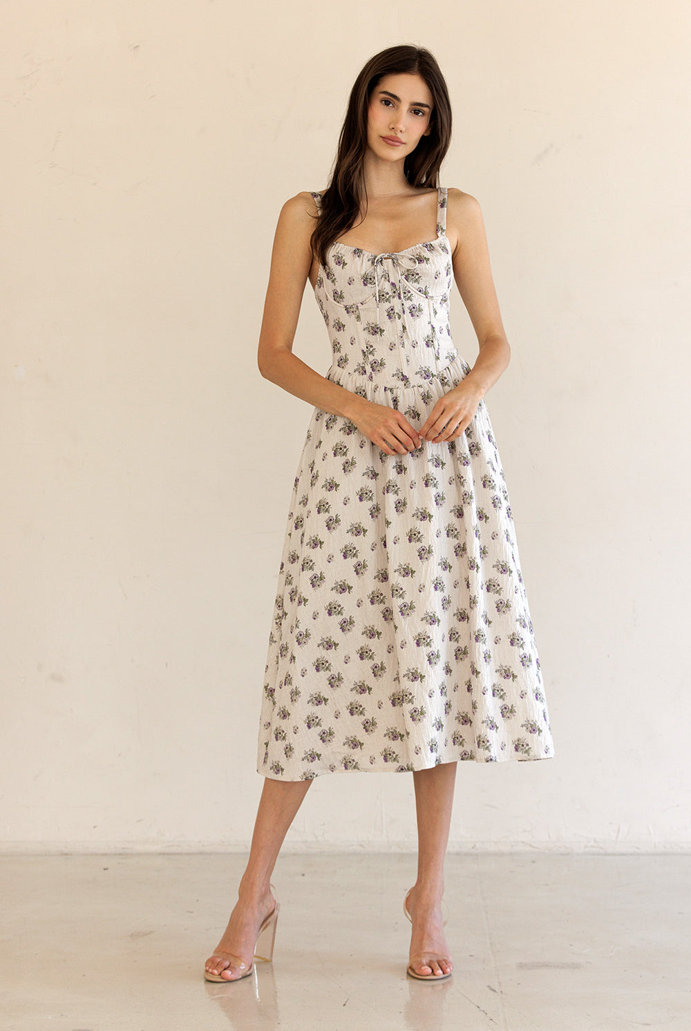 Woman wearing a floral dress against a plain background