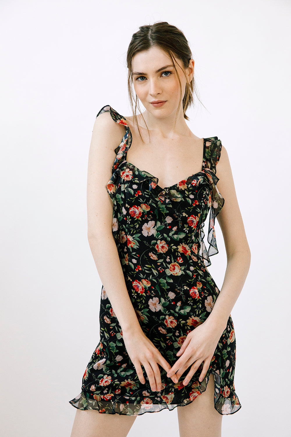 Woman wearing a black dress with a floral pattern against a white background