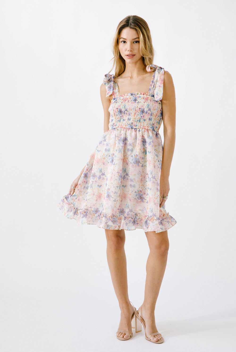 Alternative view of a woman wearing a floral dress on a white background