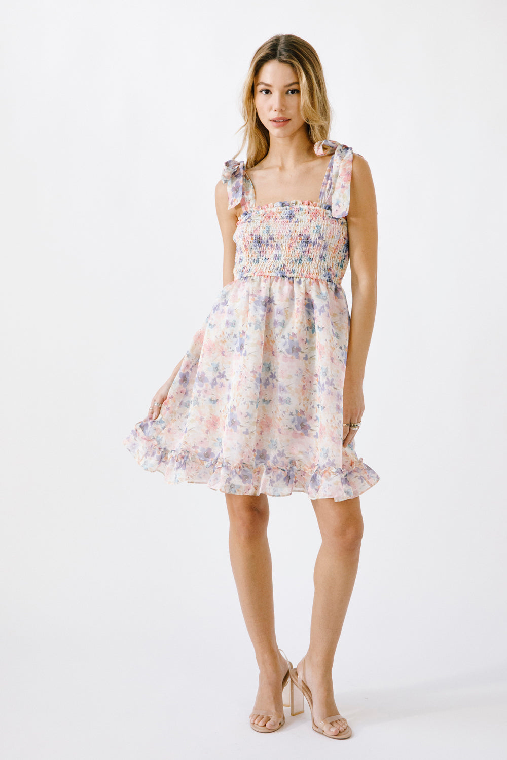 Alternative view of a woman wearing a floral dress on a white background