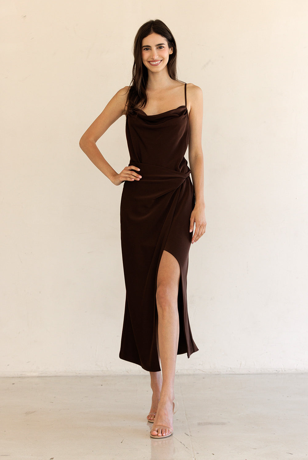 Woman wearing a brown dress with a plain background