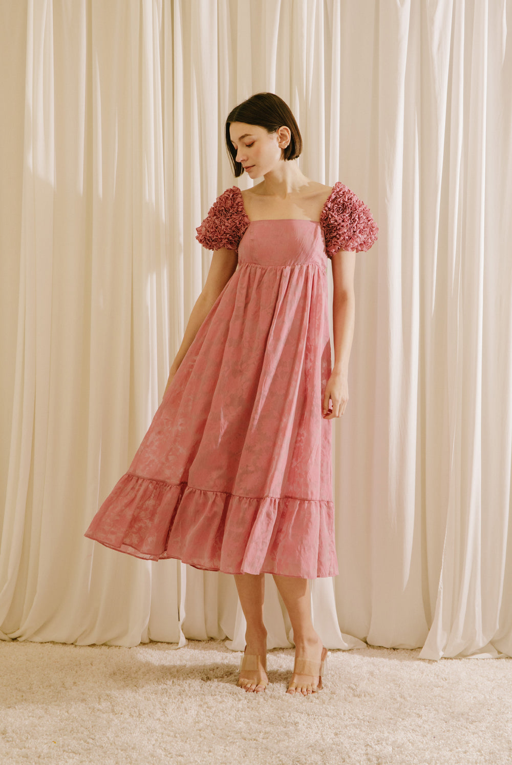 Woman wearing a pink dress with floral sleeves
