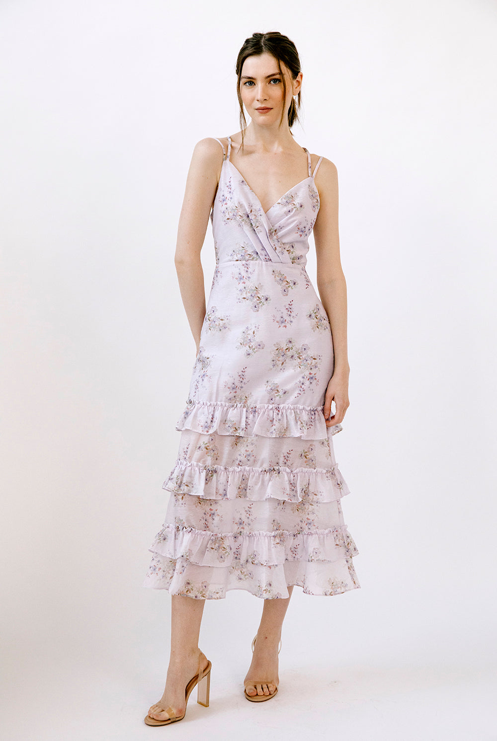 Woman wearing a lilac floral midi dress on a white background