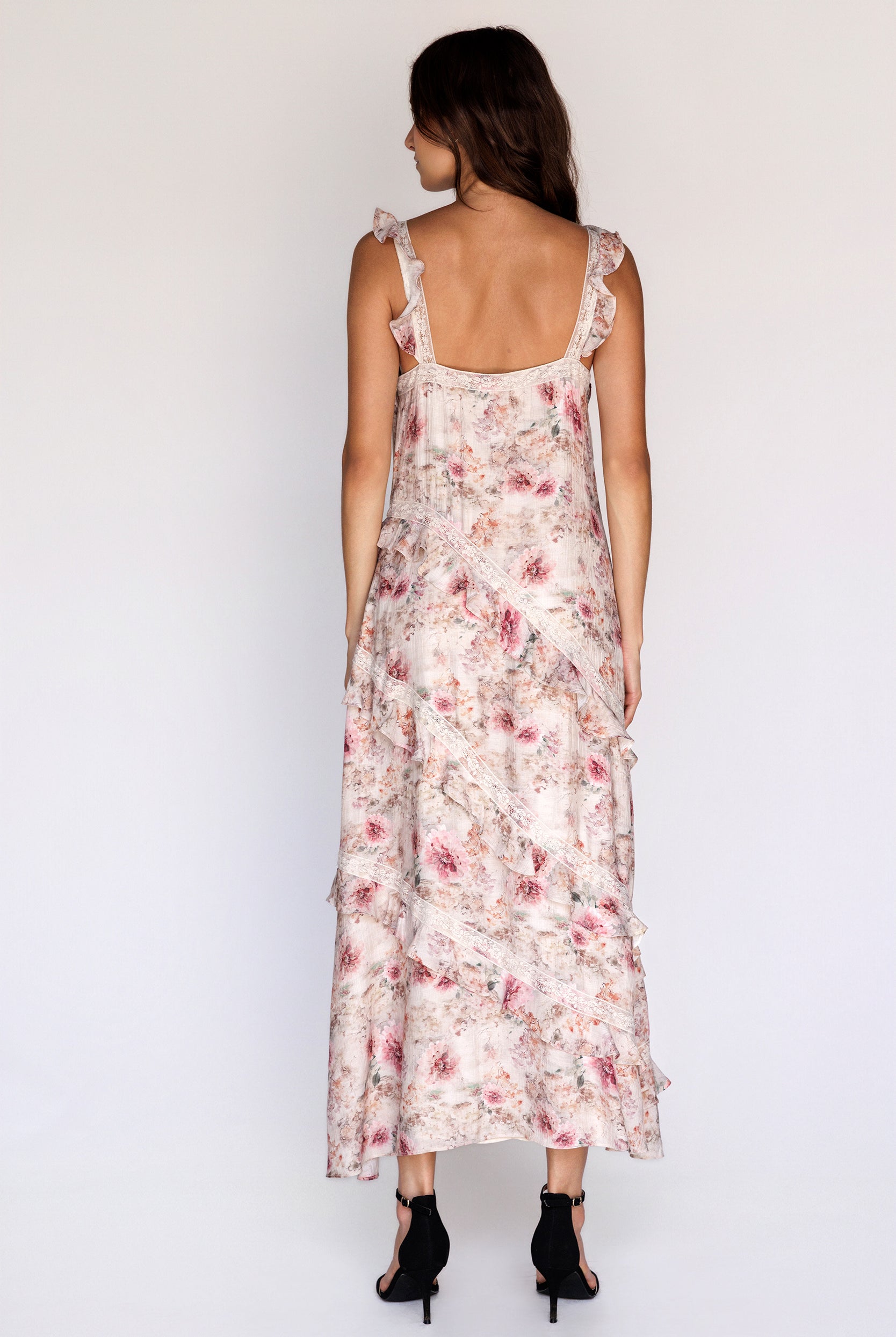 Back view of a woman wearing a floral dress on a white background