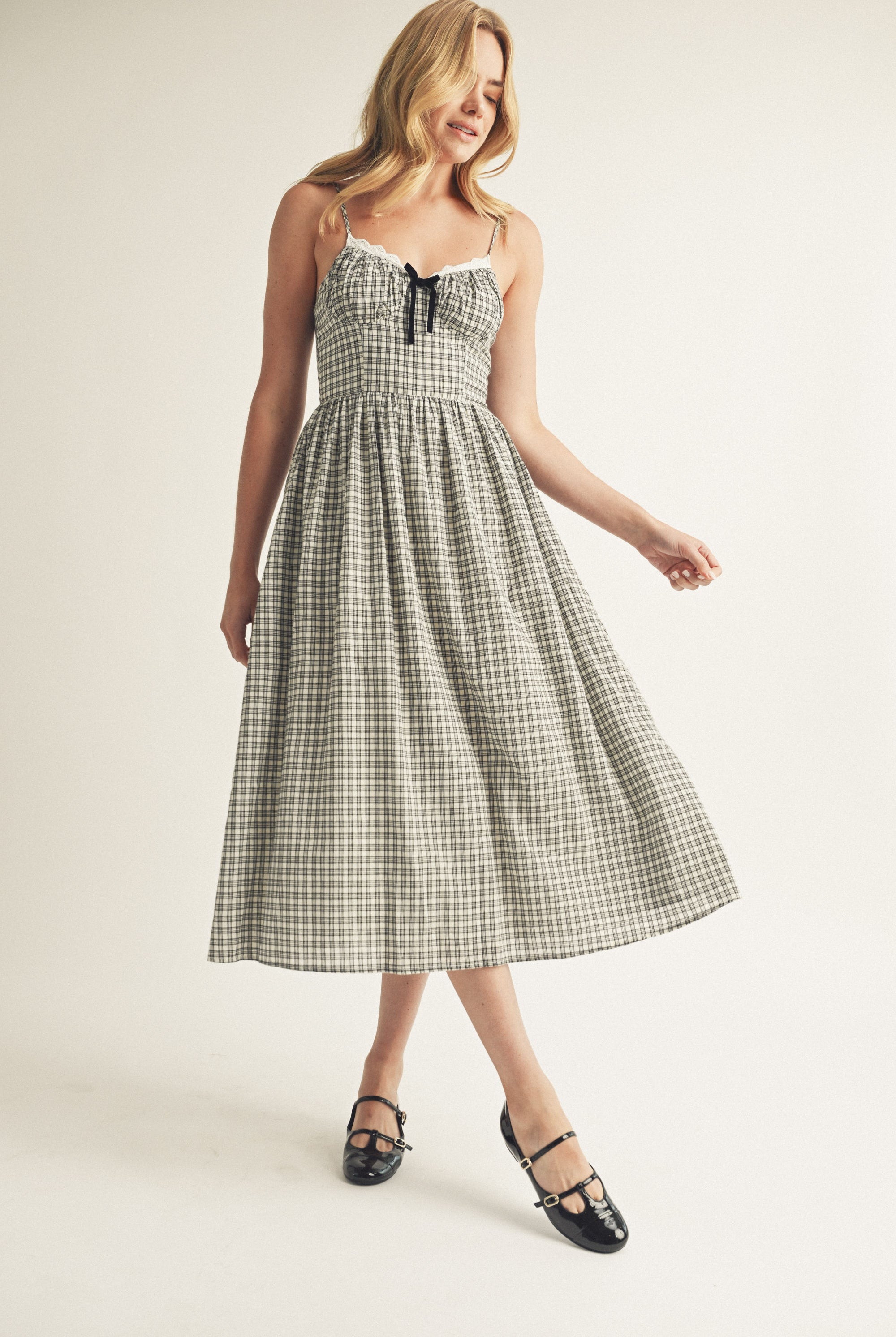 Woman wearing a black and white checkered dress on a plain background