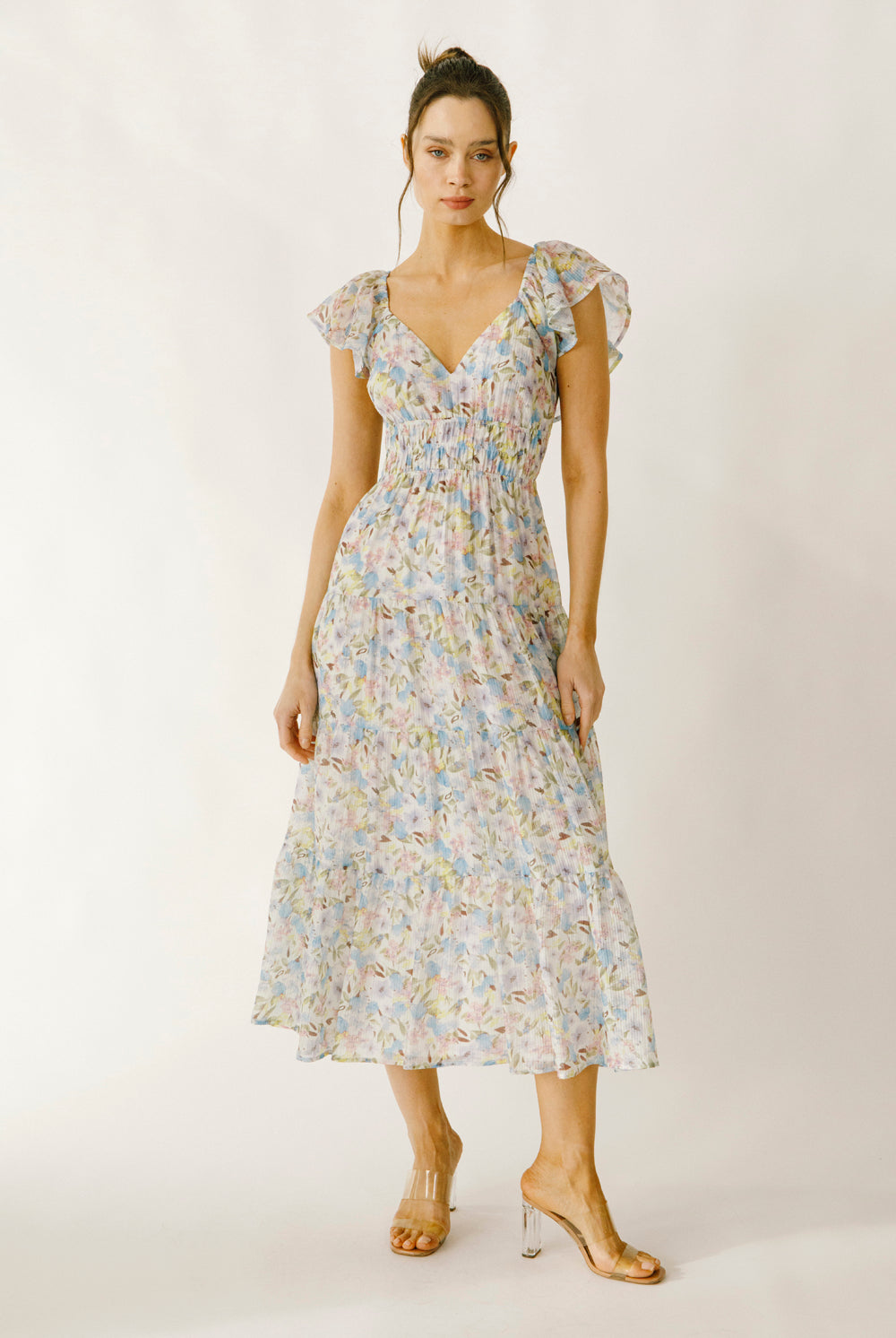 Woman wearing a blue and pink floral dress on a white background