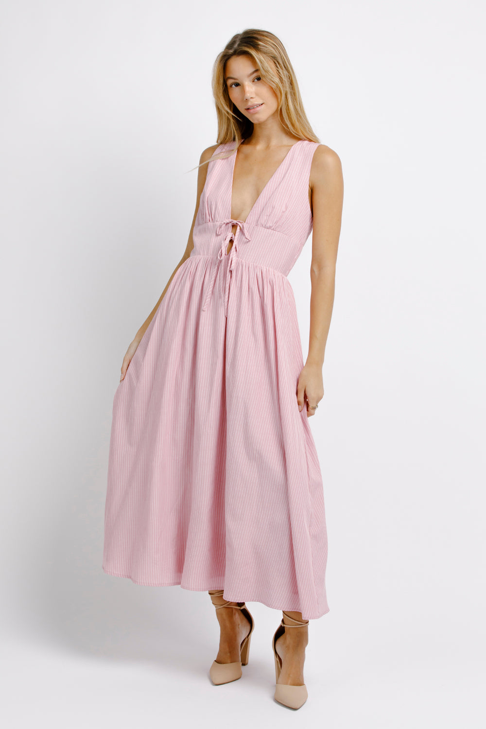 Woman wearing a pink midi dress on a white background