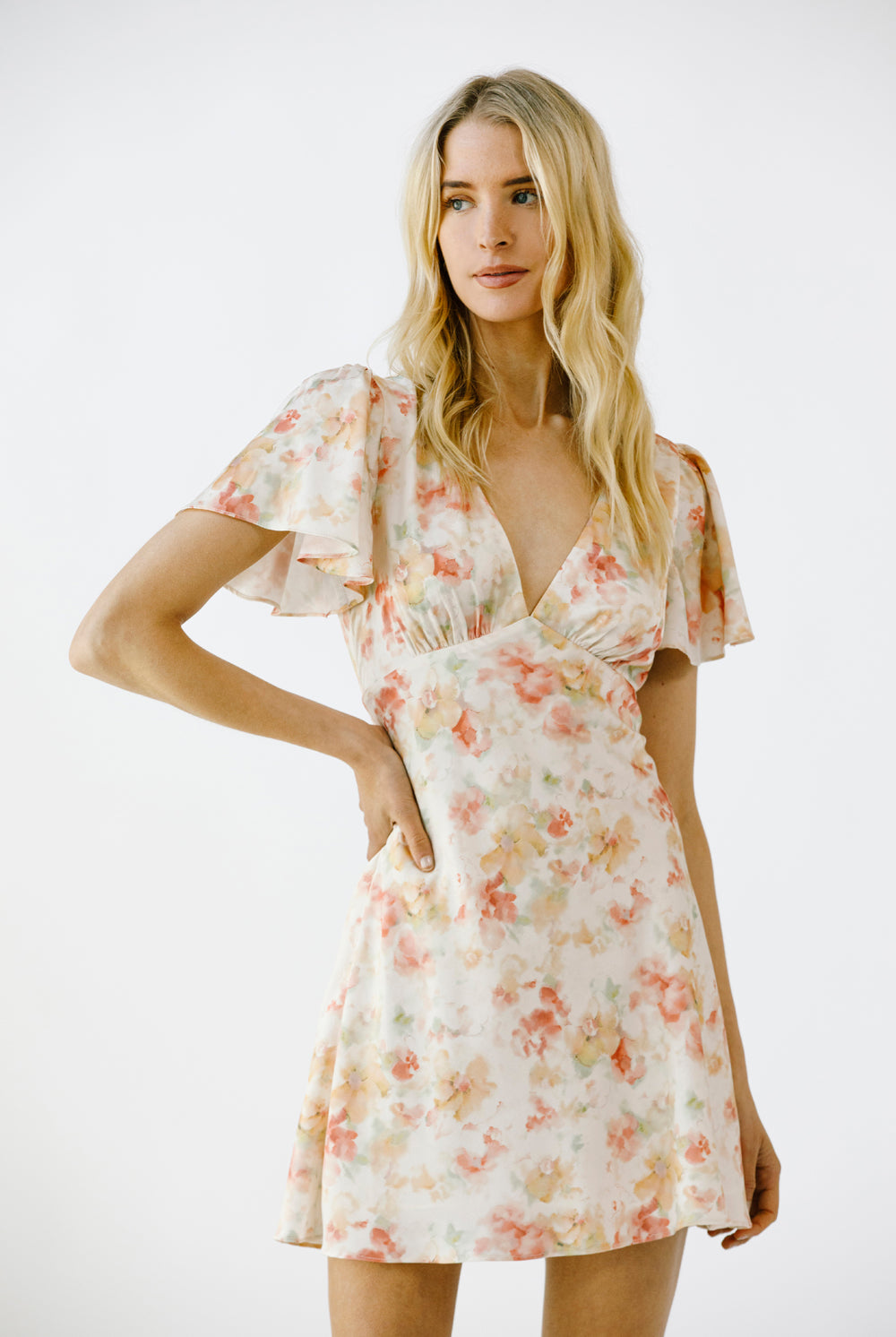 Woman wearing a mini floral dress on a white background