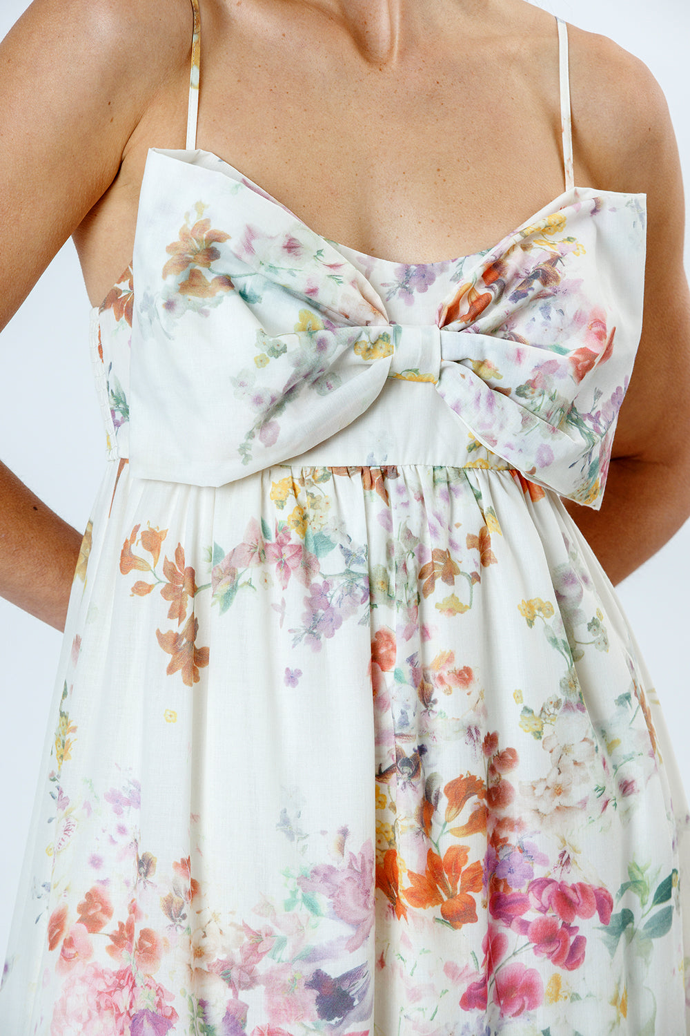 Floral dress with a large bow detail on a white background