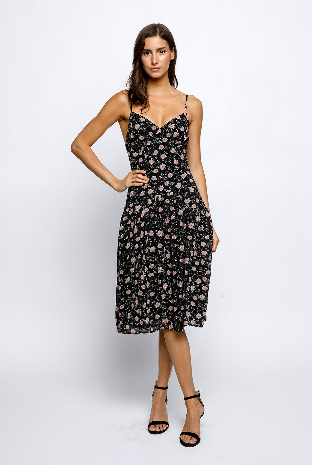 Woman wearing a black floral dress on a white background