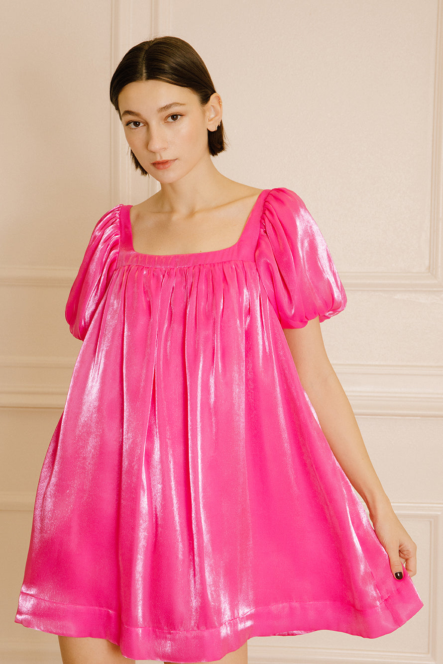Woman wearing a pink nightgown against a beige wall