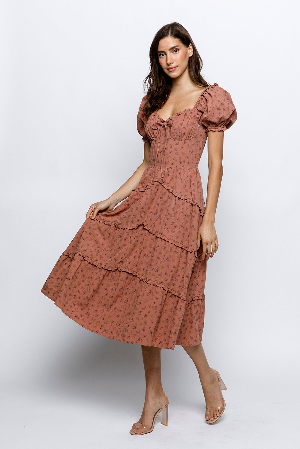 A model wearing a floral bustier midi dress with short puffy sleeves and a sweetheart neckline.