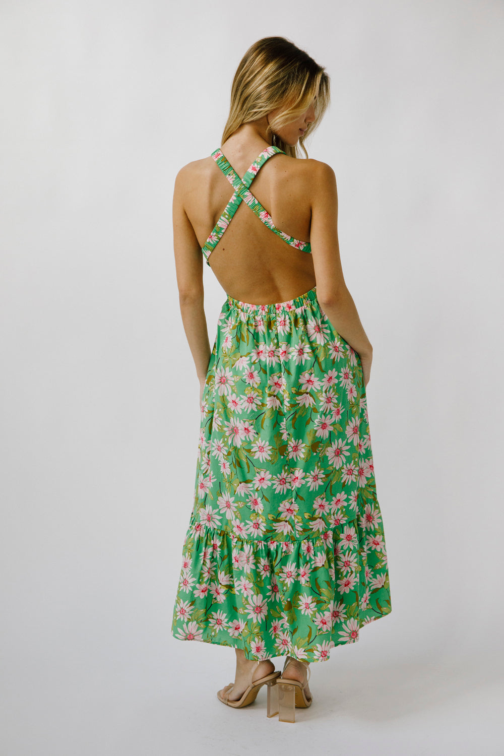 Woman wearing a green floral dress with a white background