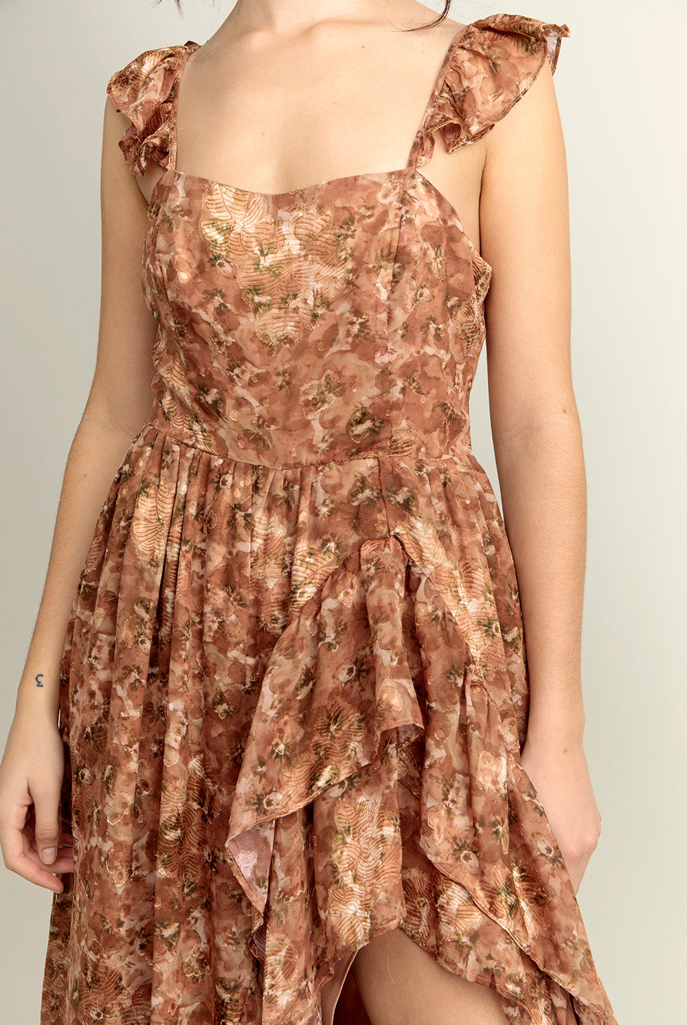 Close-up view of a brown floral dress with a neutral background