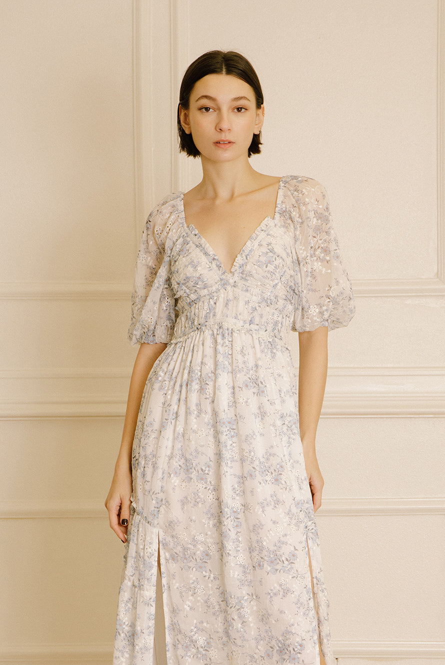 Woman wearing a floral dress against a neutral background