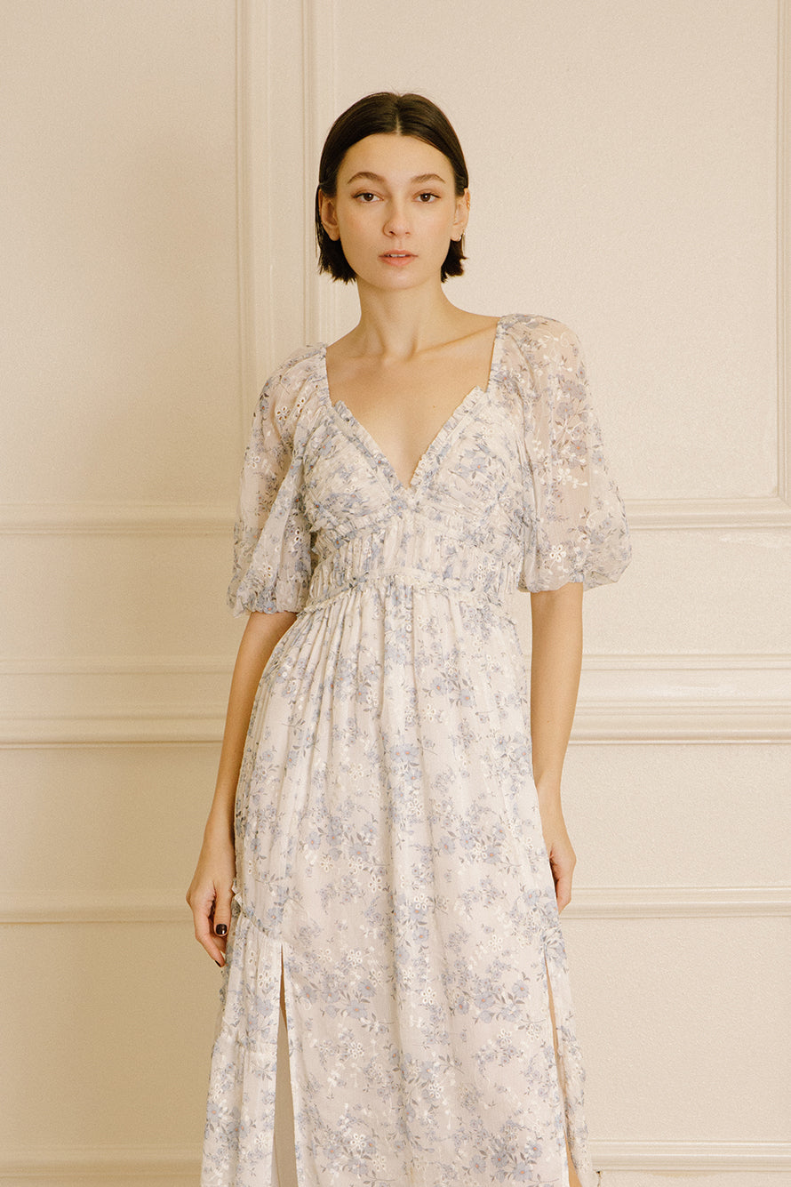 Woman wearing a floral dress against a neutral background