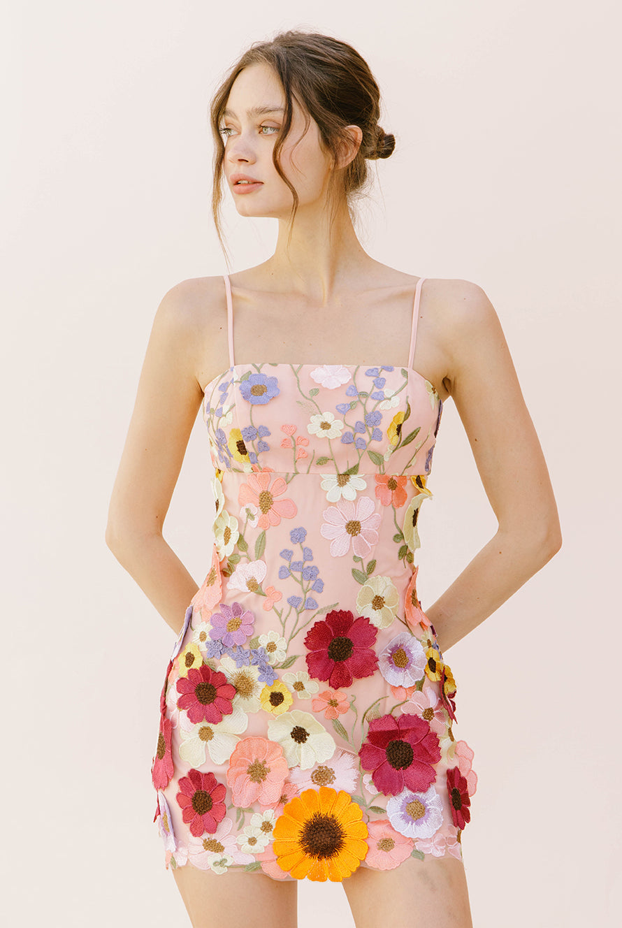Alternative view of a woman wearing a floral dress on a plain background