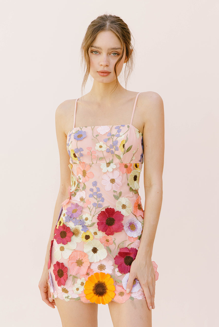 Woman wearing a floral dress on a plain background