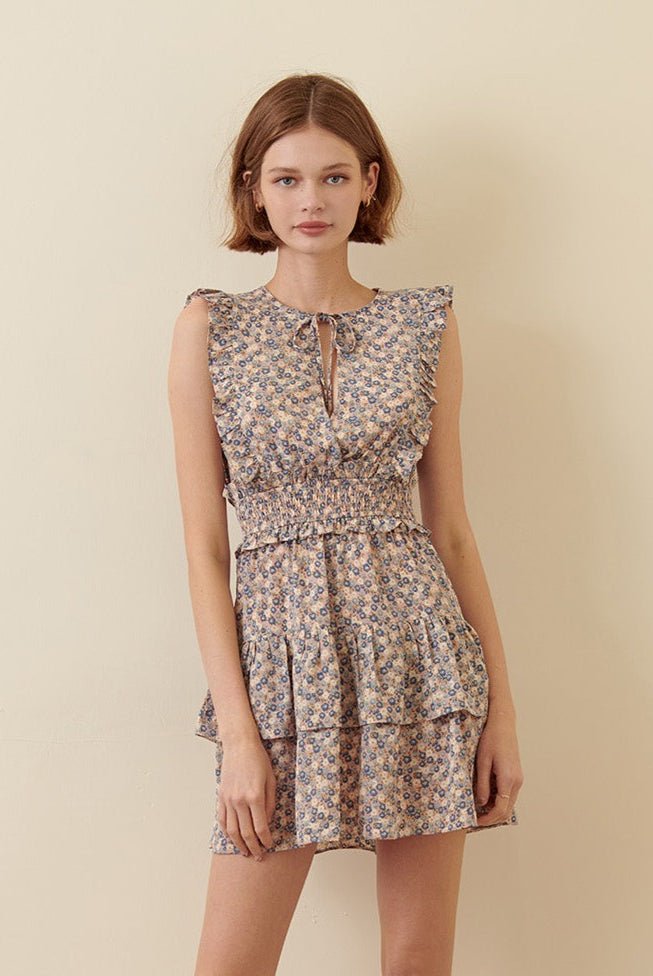 Woman wearing a blue floral dress on a beige background