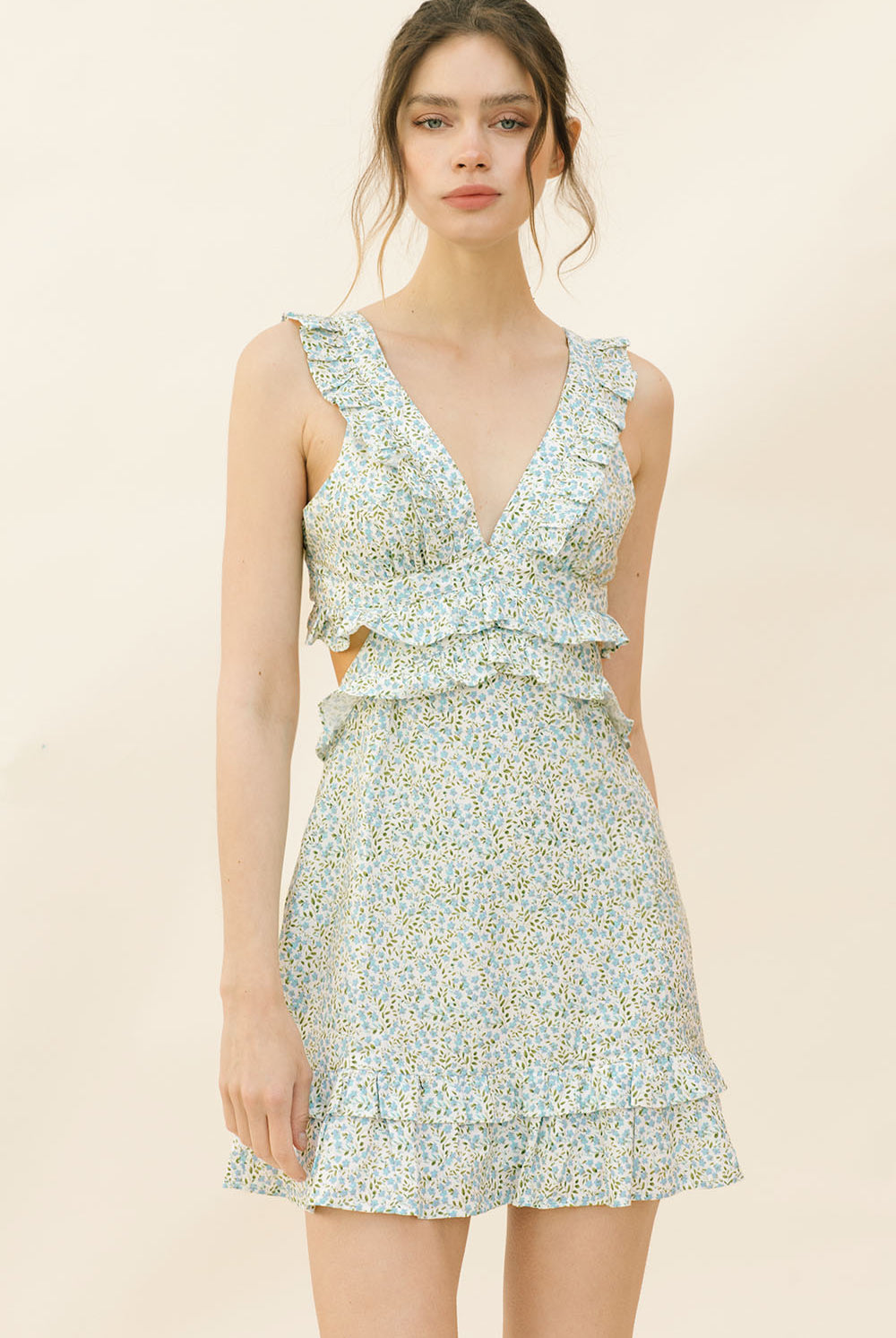 Woman wearing a blue dress with floral pattern on a beige background