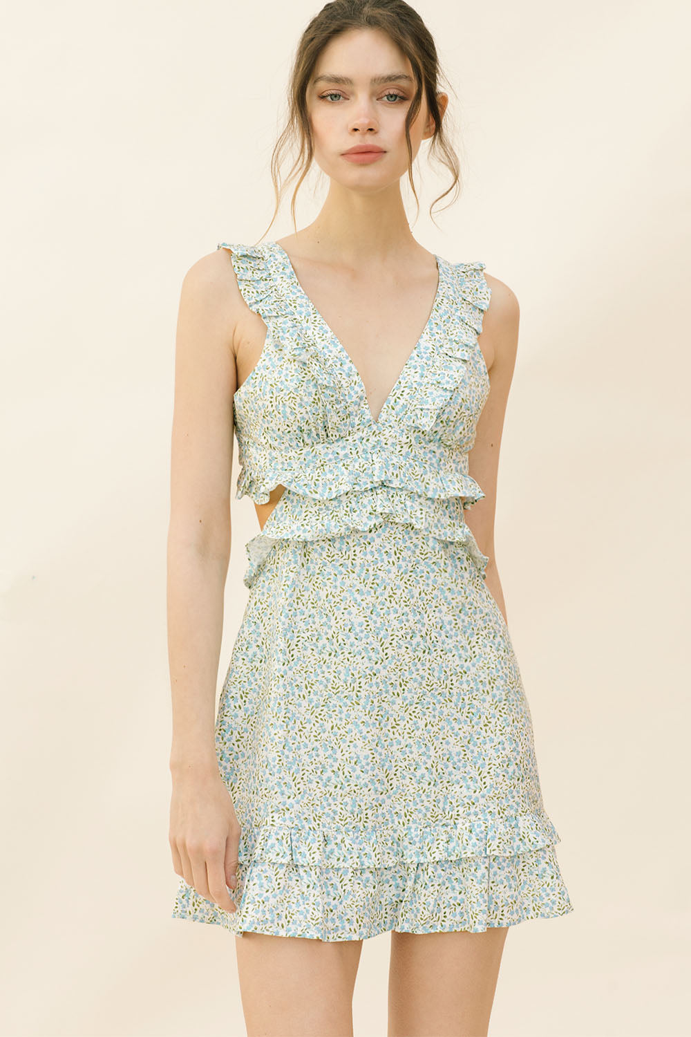 Woman wearing a blue dress with floral pattern on a beige background