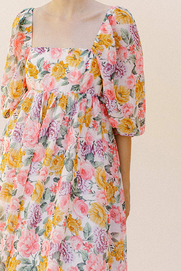 Pink floral midi dress against a plain background