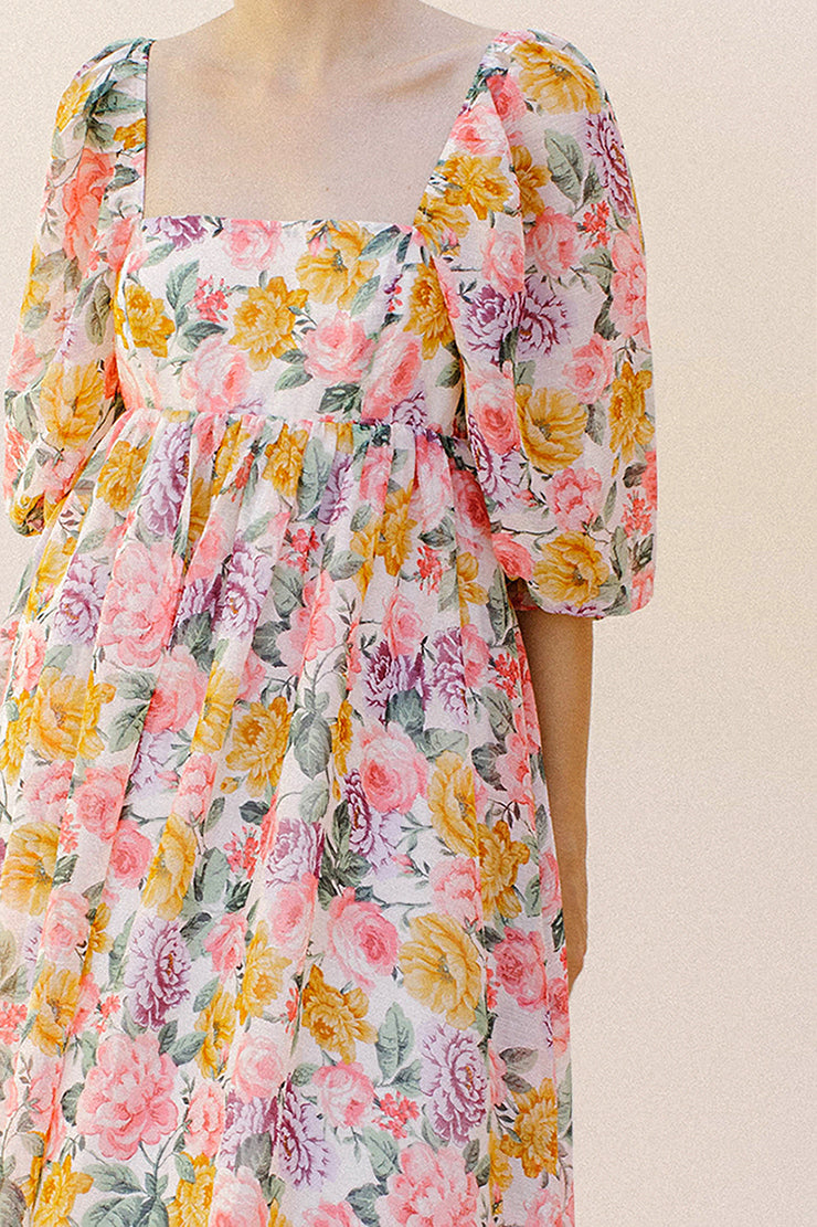 Pink floral midi dress against a plain background