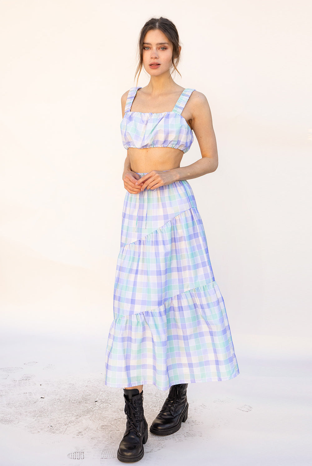 Woman wearing a pastel top and skirt on a white background