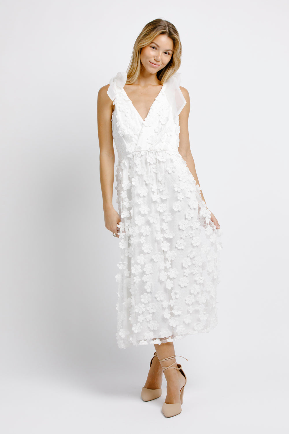 Woman wearing a white floral dress on a white background
