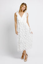 Woman wearing a white floral dress on a white background