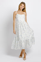 Woman wearing a white and blue floral dress on a plain background