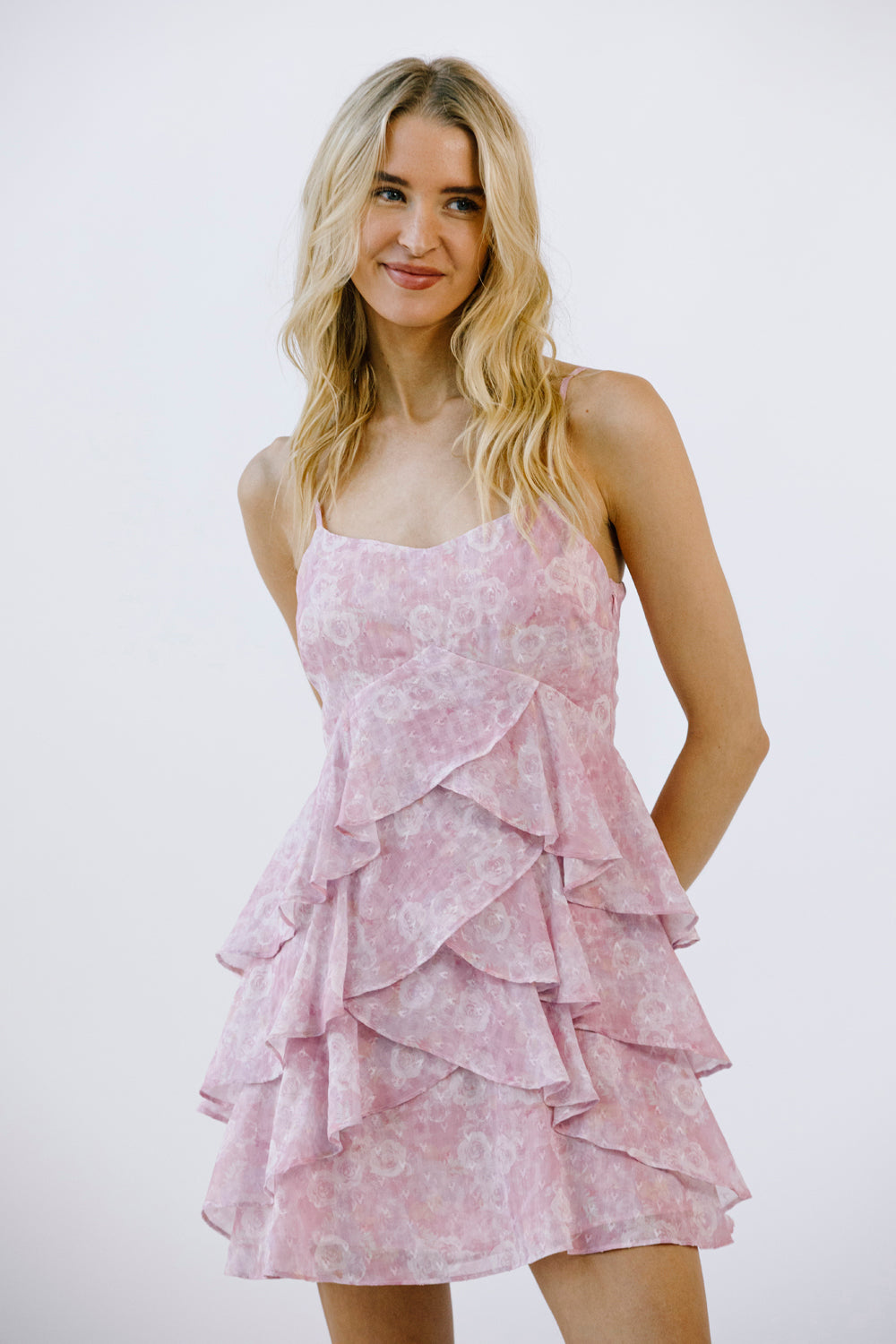 Woman wearing a pink ruffled dress against a white background