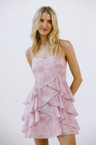 Woman wearing a pink ruffled dress against a white background